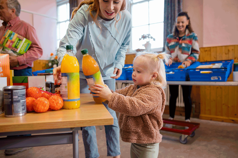 Mutter und Kinder freuen sich bei der Rostocker Tafel über Spenden